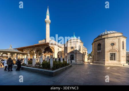 Mosque with green and gold domes and minaret in Karatay, Konya. The Mevlana Museum (Turkish: Mevlânâ Müzesi) is the mausoleum of Jalāl ad-Dīn ar-Rūmī with the adjoining lodge of the Mevlevi dervish brotherhood. Visitors view historical tombs. Karatay, Konya, Central Anatolia Region, Turkey Stock Photo