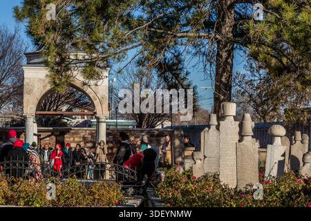 The Mevlana Museum (Mevlânâ Müzesi) in Konya's Karatay district, Turkey, shows visitors viewing historic gravestones of dervishes. The museum is the mausoleum of the Sufi mystic Rumi (1207–1273), with an adjoining mosque and former dervish lodge; the turquoise dome built over his grave in 1274 is considered a symbol of Konya. Stock Photo