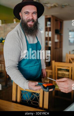 Smiling waiter taking payment from customer Stock Photo