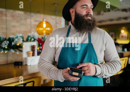 Smiling waiter taking payment from customer Stock Photo
