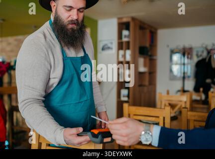 Smiling waiter taking payment from customer Stock Photo
