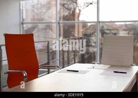 Sheets of paper and pens on wooden table in office, closeup Stock Photo