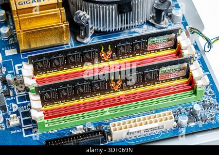 Computer main circuit board showing memory slots with RAM Stock Photo
