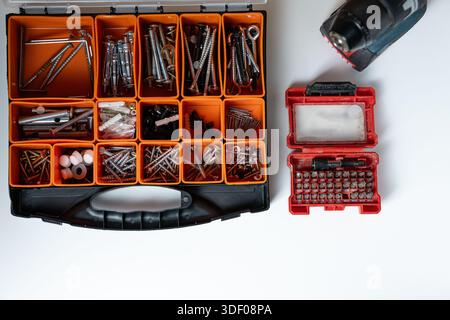 Top view of a toolbox with assorted screws, nails, and drill bits. Stock Photo