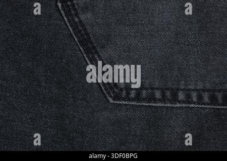 Dark gray background or texture of denim fabric with seam Stock Photo