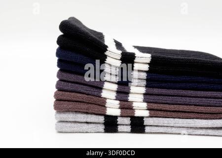 Stack of folded cotton socks in various colors with stripes on white background Stock Photo