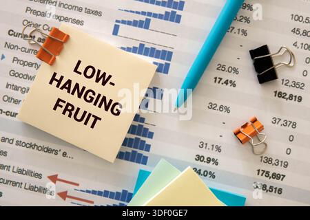 Hand reach to grab the hanging apple isolated on white background. Low hanging fruit concept. Clipping path. Stock Photo