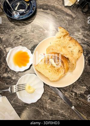 kaya toast Peranakan dish, Slices of toasted bread served with butter and coconut jam on a marble table in a cafe setting Ipoh malaysia Stock Photo
