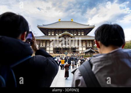 Tourists taking photos of the Kondo Hakkaku Toro of Todai-ji Temple, Nara, Japan Stock Photo