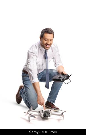 Man kneeling and starting a mini drone isolated on white background Stock Photo