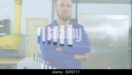 Standing tech wearing blue coverall crossing arms on factory floor, with AR overlay and robot arm Stock Photo