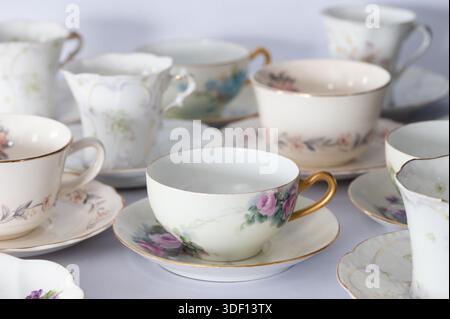 Side view of a table full of vintage teacups on saucers Stock Photo