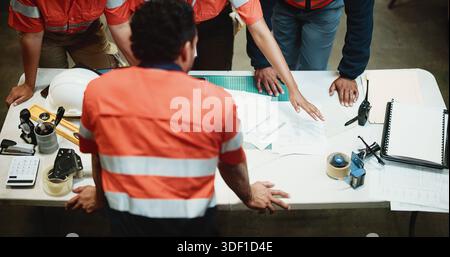 Above, logistics or team in warehouse with paper, discussion or order backlog in supply chain. Distribution, people or workers with documents Stock Photo