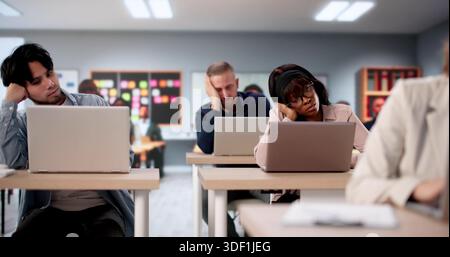 Bored College Students Turn To Laptops In Classroom Study Session. Stock Photo