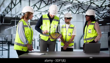 African-American Technician And Asian Engineer Optimize Semiconductor Wafer Manufacturing Efficiency. Stock Photo
