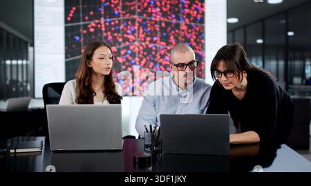 Team Of Diverse Software Engineers Securing Server Control In Office. Stock Photo