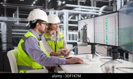 Female Engineer Expertly Operates Gas Turbine In Power Plant Control Room. Stock Photo