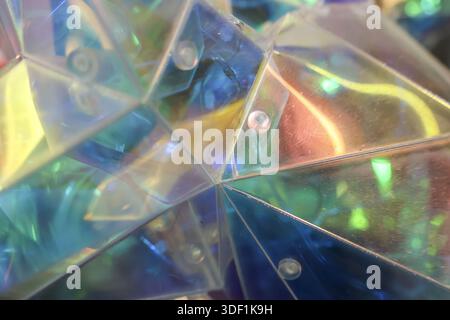 Abstract and iridescent plastic background texture with futuristic triangle pattern creating vibrant mood featuring reflection of colorful light with Stock Photo
