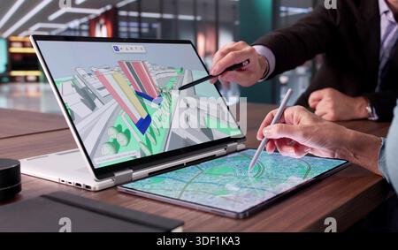 Multicultural Engineer And Real Estate Professional Inspecting GIS Mapping Stock Photo