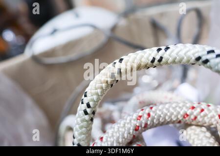 Detail of sturdy white nylon braided rope with black and red tracers featuring rough textured surface and representing secure strength and safety in m Stock Photo