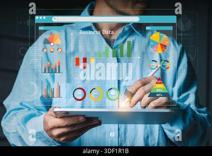Businessman analyzing a large virtual business data dashboard and complex charts on a tablet. Concept of data analysis and business intelligence. Stock Photo