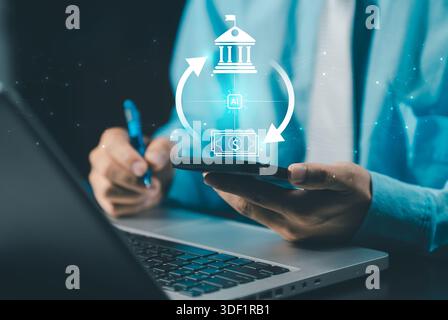 A businessman using a smartphone and laptop, with an overlay graphic showing an AI-powered financial transaction cycle between a bank/institution icon Stock Photo