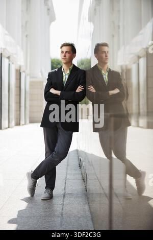 Young fashion man standing against the wall Stock Photo