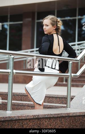 Beautiful young woman leaning on the handrail Stock Photo
