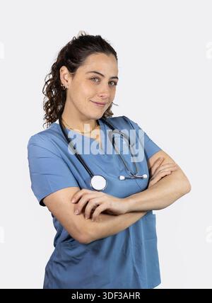Young woman medical worker in blue scrubs posing with confidence Stock Photo