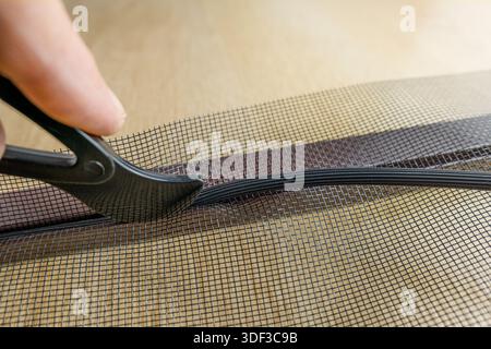 Installing the net into the window aluminium frame or door Stock Photo