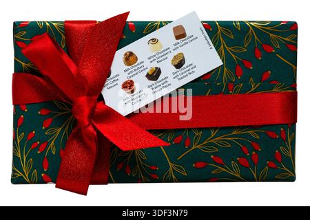 Box of Christmas chocolates with red ribbon and tag isolated on white background - non-alcoholic milk dark & white chocolates with assorted fillings Stock Photo