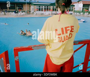 A female life guard watches over the outdoor pool, Butlins Skegness, UK. Stock Photo