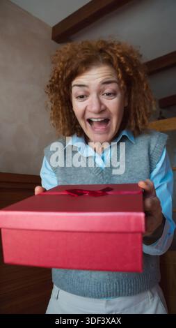 Woman expressing surprise receiving a red gift box Stock Photo