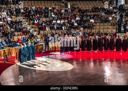 After the end of the Şeb-i Arus ceremony at the Mevlana Kültür Merkezi in Karatay, Konya, Turkey, a venue that holds up to 3,000 people, the dervishes are once again wrapped in their black cloaks, and the Şeyh (sheikh/master) strides towards the exit. The dervishes kneel in a long row, while the Şeyh and several attendants in green robes stand at the edge of the frame. Şeb-i Arus is the annual festival marking the death anniversary (17 December) of the mystic poet Rumi (Jalāl ad-Dīn ar-Rūmī, 1207–1273), founder of the Mevlevi order, celebrated as a spiritual union with God. Stock Photo