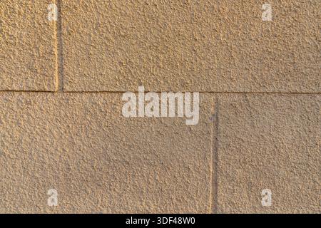 Beige stone wall texture with rectangular blocks and rough architectural surface Stock Photo