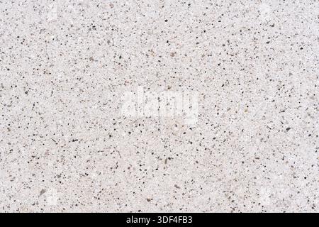 High-resolution top view of a white terrazzo or quartz surface. Seamless pattern with small grey and brown stones, ideal for interior design Stock Photo