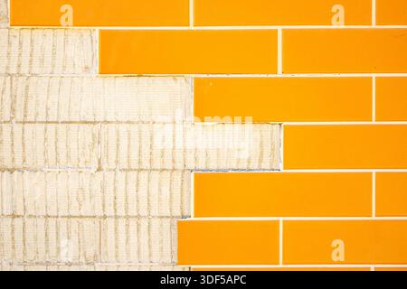 GOIANIA GOIAS BRAZIL - JANUARY 10 2026: Detail of a wall with ceramic tiles imitating orange bricks, with some missing. Stock Photo