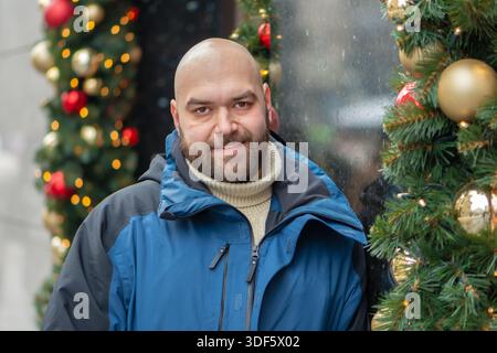 A smiling middle-aged man next to the festive decor Stock Photo
