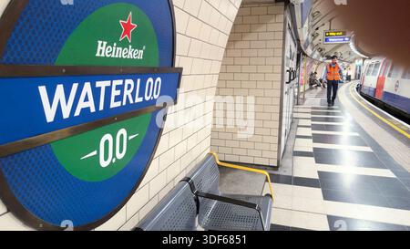 London, UK. 11th January 2026. TFL staff in high-visibility vests assist passengers at Waterloo Underground station where a Heineken advertising campaign has replaced the traditional TfL roundel with corporate beer branding. The Dutch brewery launched a two-week campaign on Friday temporarily rebranding multiple London Underground station signs across the capital's transport network, with station workers helping commuters navigate the altered wayfinding signage at major stations including Waterloo, Baker Street, Oxford Circus and Piccadilly Circus. Credit:glosszoom/17�Թ����� Live News Stock Photo