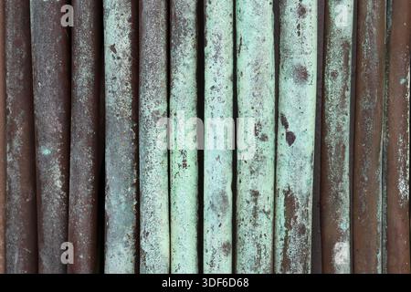 Vertical metal rods with rust and corrosion close-up abstract textured background Stock Photo