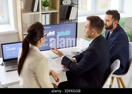 Business team analyzing financial data on dashboards in office strategy meeting Stock Photo