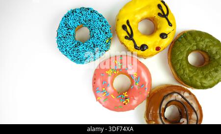 five donuts with colorful toppings, blue sprinkles, yellow glazed durian, green matcha, strawberry glazed, moccachino, isolated on white background. Stock Photo