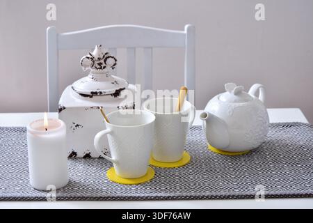 White ceramic tea set with two cups and a teapot on the table Stock Photo
