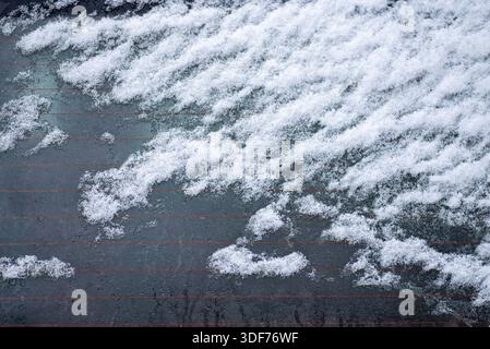 An abstract natural background featuring the uneven, wave-like texture of a snow drift with subtle shadows and blueish tints. Stock Photo