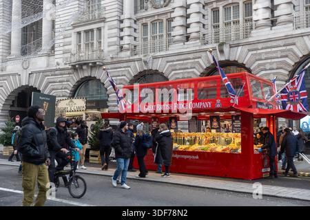 London, UK, 7 December 2025, A red double-decker bus themed food stall for the Great British Fudge Company on a Regent street during the Christmas sea Stock Photo