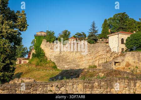 Ancient stone walls of Belgrade Fortress (Kalemegdan) on a hill, with ivy-covered tower, fortification buildings and Chapel of Saint Petka, Serbia. Stock Photo