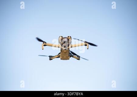 Hamburg, Germany - September 30, 2025: Small Consumer Drone DJI Mini 5 Pro  In Flight Against Blue Sky - Low Angle Medium Shot Stock Photo