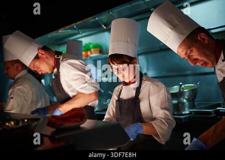 Chefs working together in professional restaurant kitchen Stock Photo
