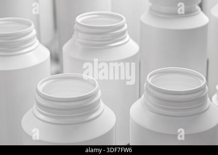Group of empty unlabeled white plastic medicine jars, close up shot, abstract background Stock Photo