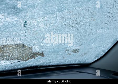Snow and water droplets on the car window, view from inside the car. Stock Photo